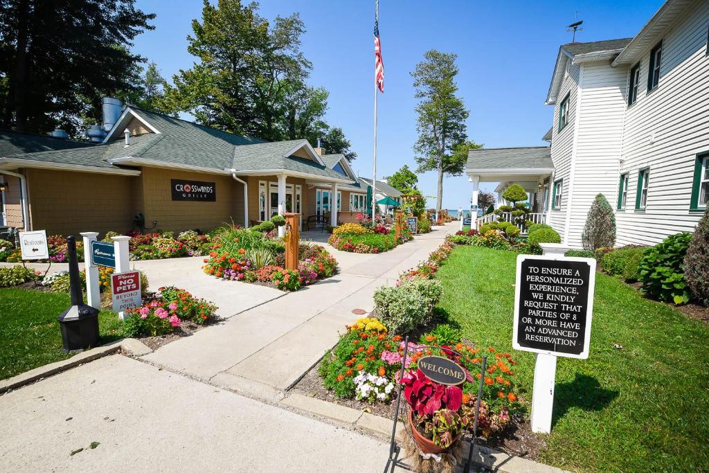 a house with a sign in a yard with flowers at The Lakehouse Inn Geneva in Geneva-on-the-Lake