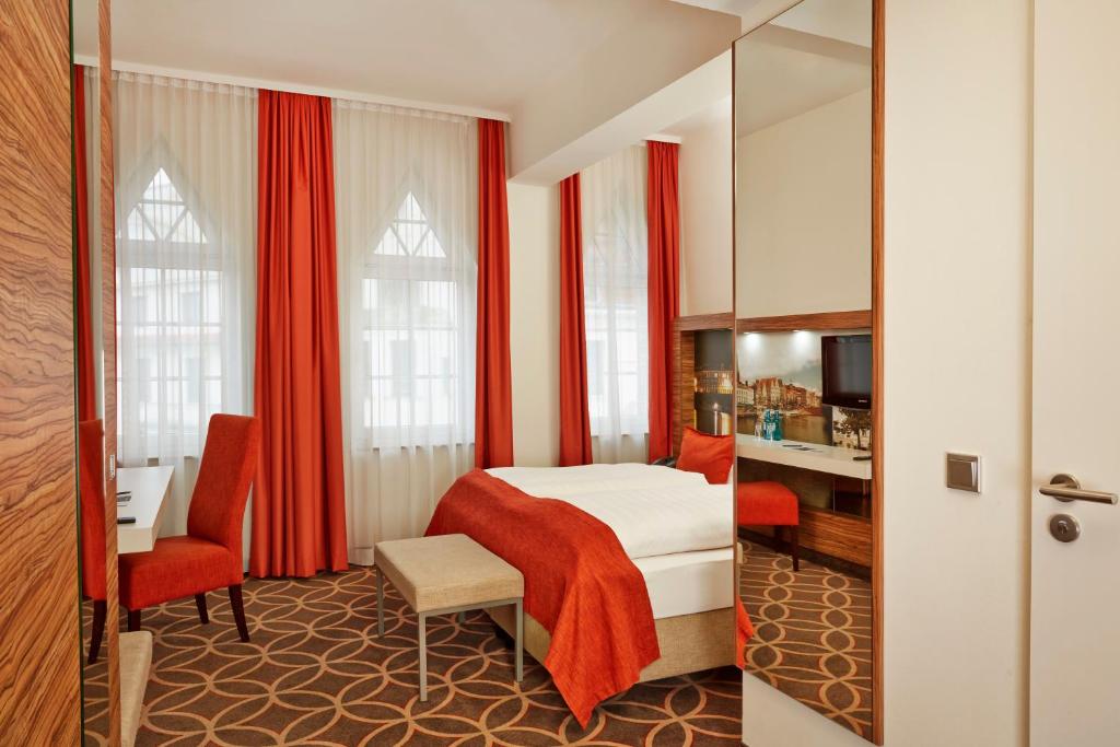 H+ Hotel Lübeck tesisinde bir odada yatak veya yataklar