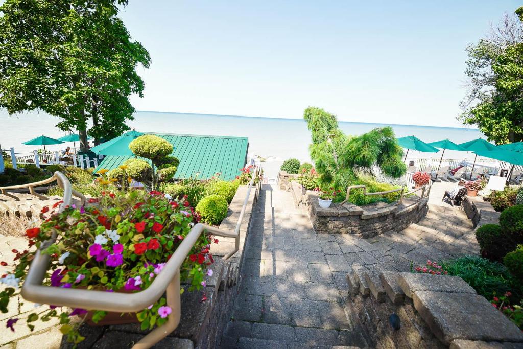 a garden with flowers and tables and umbrellas at The Lakehouse Inn Geneva in Geneva-on-the-Lake