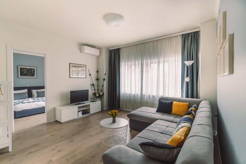 a living room with a couch and a bed at Point Rijeka in Rijeka