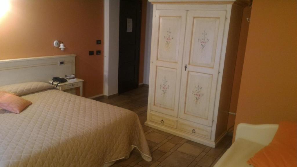 a bedroom with a bed and a white cabinet at Agriturismo La Dimora Del Contadino in Mondovì