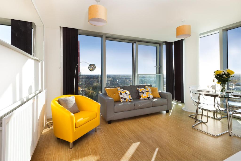 uma sala de estar com uma cadeira amarela e um sofá em 2 Bedroom 2 Bathroom Apartment in Central Milton Keynes with Free Parking and Smart TV - Contractors, Relocation, Business Travellers em Milton Keynes