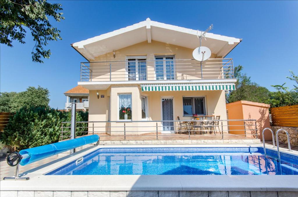 a villa with a swimming pool in front of a house at Dalmatian village charm - spacious villa with pool near Trogir in Primorski Dolac
