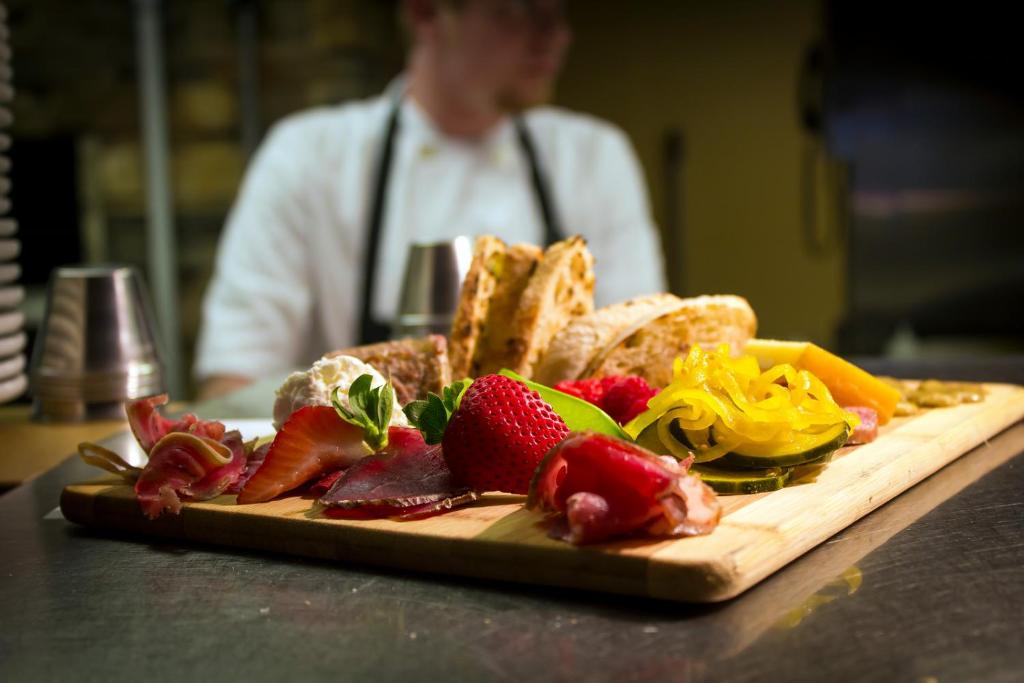 a plate of food on a cutting board with fruit at The Lakehouse Inn Geneva in Geneva-on-the-Lake
