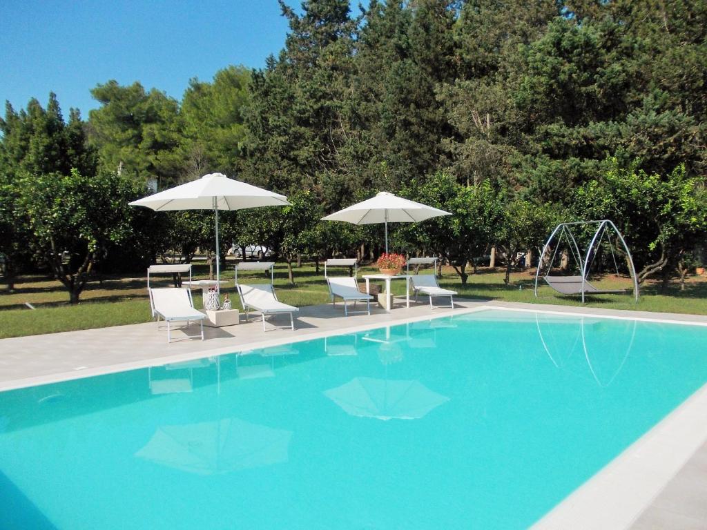 uma piscina com cadeiras e guarda-sóis em B&B Villa I 2 Leoni em Lecce