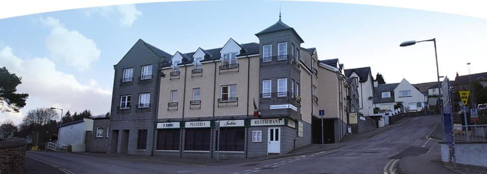 um grande edifício ao lado de uma rua em Bank Street Lodge em Fort William