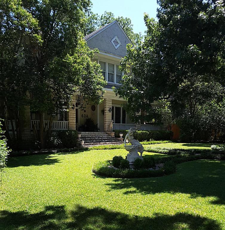 a house with a statue of a bear in the yard at Strickland Arms Bed and Breakfast in Austin