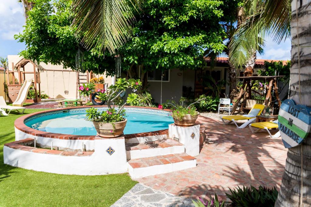a swimming pool with plants in a yard at Casalina Garden 2 blocks to Palm Beach & Kitesurfing school in Palm-Eagle Beach