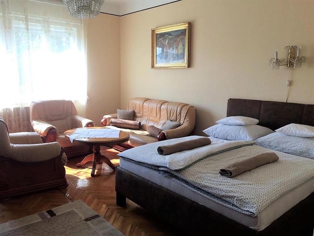 Fejedelem Vendégház في إغير: غرفة معيشة بها سريرين وأريكة وطاولة