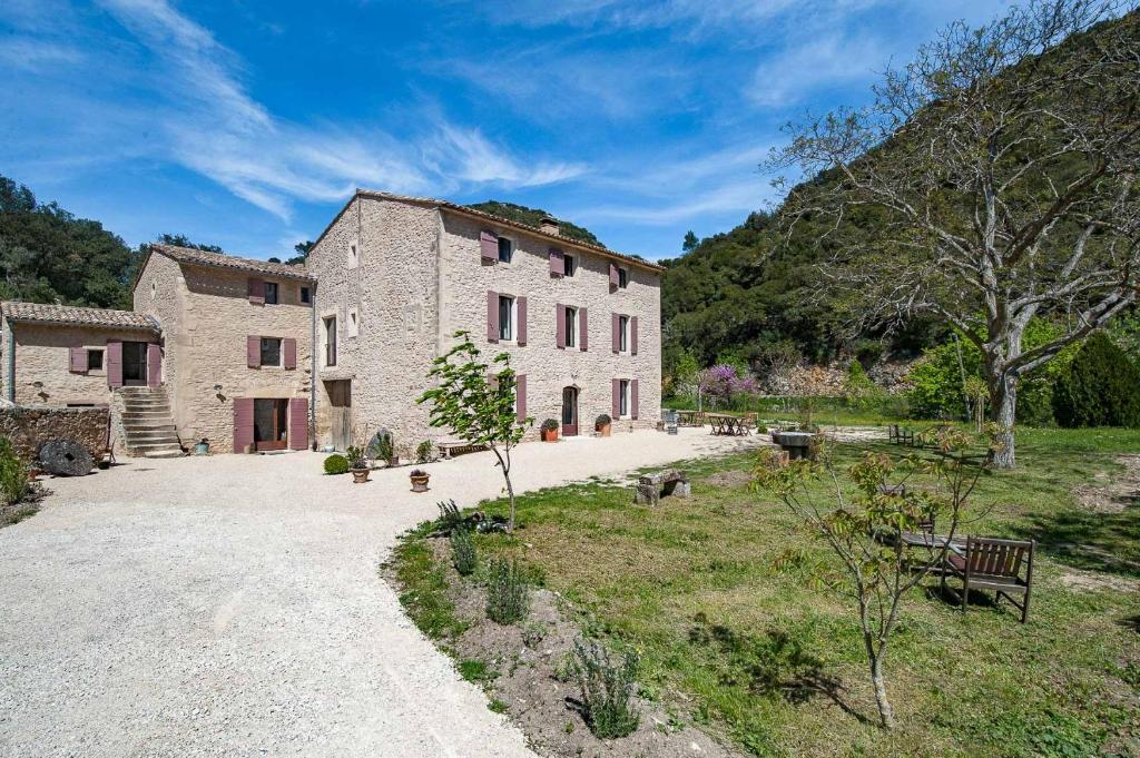 un gran edificio de piedra en medio de un campo en La Ressence Luberon en Bonnieux