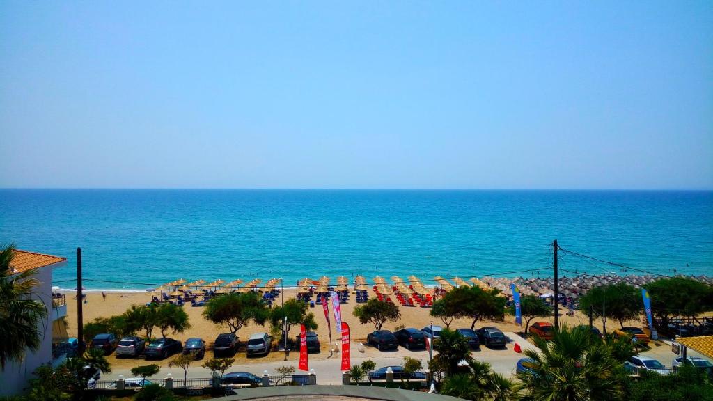 a beach with a lot of chairs and the ocean at Vrachos Holidays Hotel in Paralia Vrachou