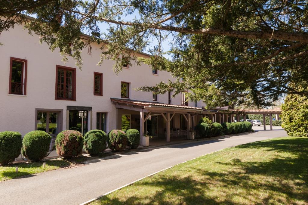 un gran edificio blanco con entrada en Clos St Eloi, The Originals Relais (Relais du Silence), en Thiers