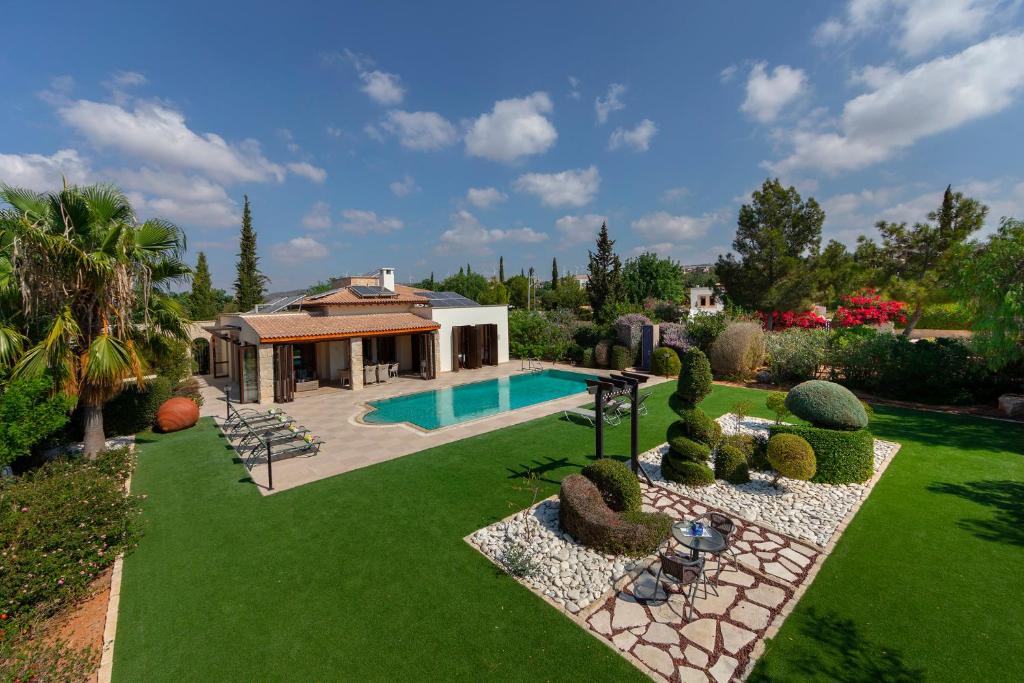 a backyard with a swimming pool and a house at Villa Oleander in Kouklia