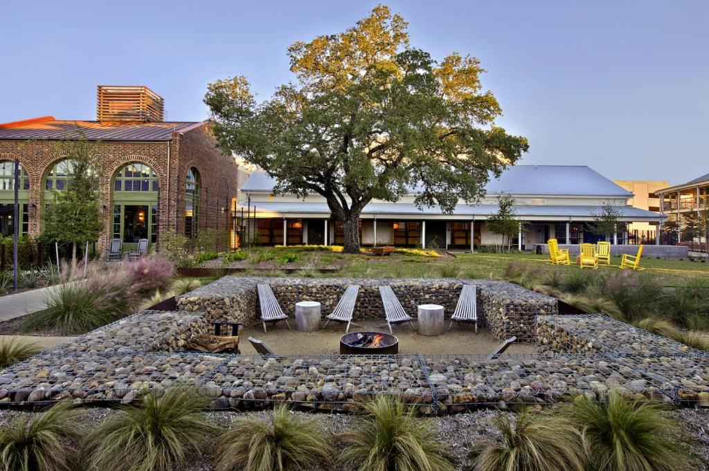 ein Gebäude mit einem Tisch und Stühlen in einem Garten in der Unterkunft Cavalry Court, by Valencia Hotel Collection in College Station