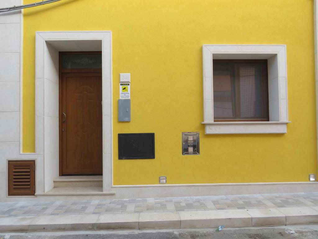 un edificio amarillo con puerta y ventana en Casa Rita, en Manduria
