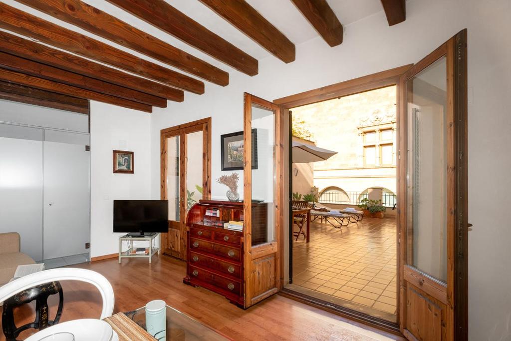 a living room with a television and a sliding glass door at Ramón Llull House in Palma de Mallorca