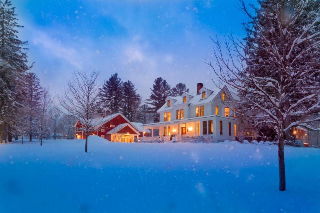 a white house in the snow at night at The Inn at Manchester in Manchester