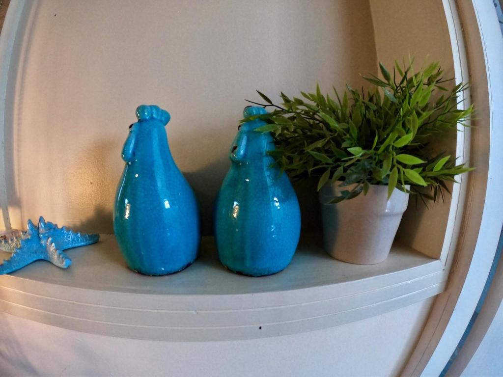 a shelf with three blue vases and a plant at Sweet Home, Only 7 Min to the beach - By SEAELO EILAT in Eilat
