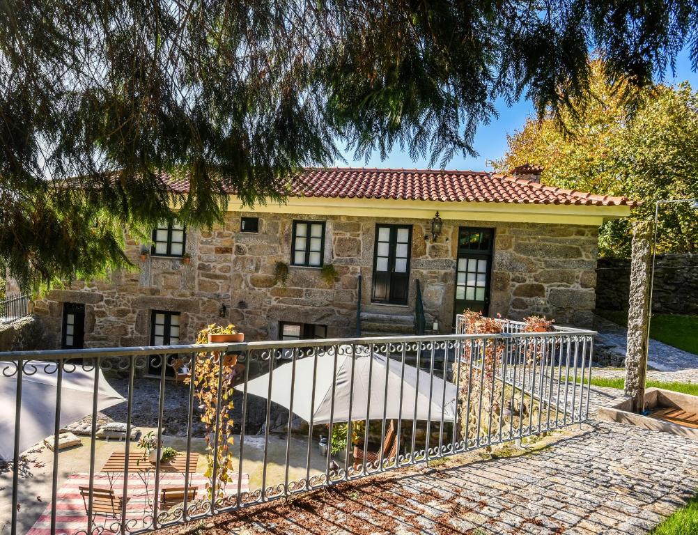 a stone house with a gate in front of it at Quinta do Cedro in Torre