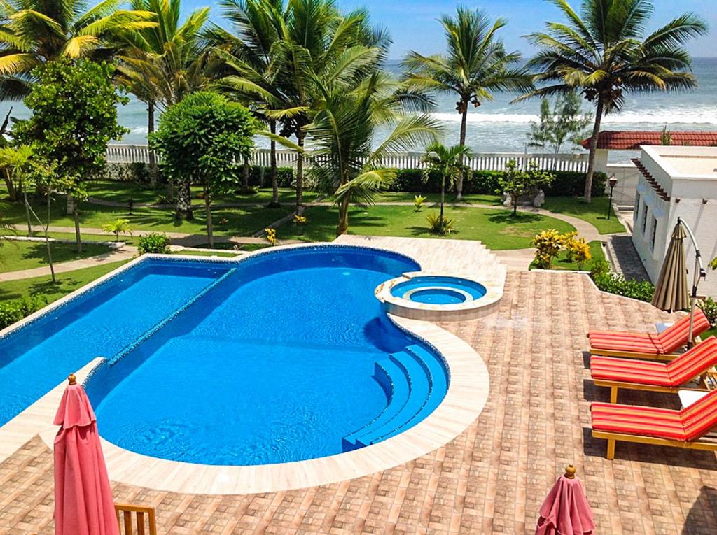 a swimming pool with a view of the ocean at Sunset Gardens in Olón