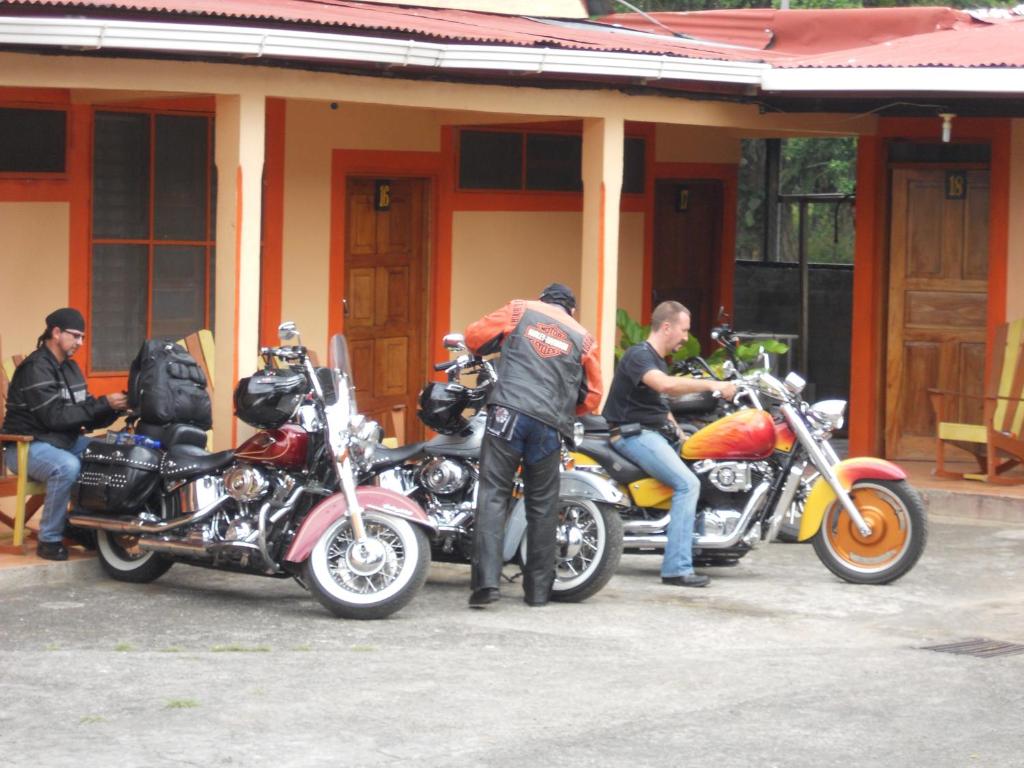 een groep mannen op motorfietsen voor een gebouw bij Cabinas Leyko in San Carlos