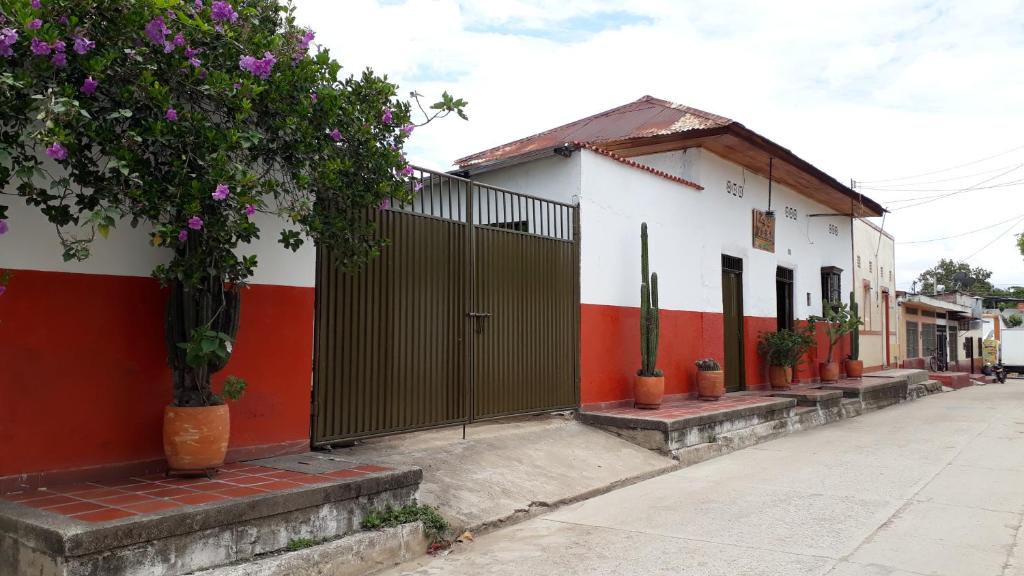 a building with red and white walls and a fence at Hostal Villa Cecilia in Villavieja