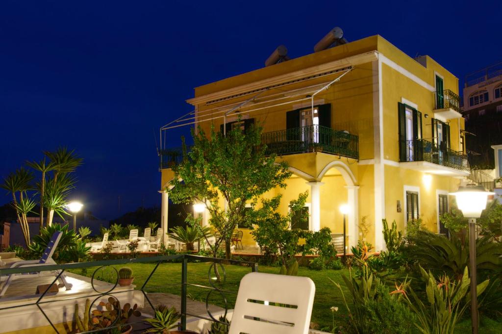 a yellow house with a balcony at night at Villa Ersilia in Ponza