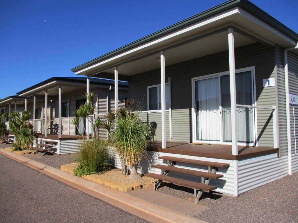 a house with a bench in front of it at The Sundowner Cabin & Tourist Park in Whyalla