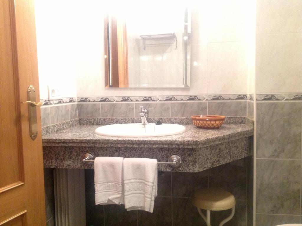 La salle de bains est pourvue d'un lavabo et d'un miroir. dans l'établissement Hostal San Froilan, à La Virgen del Camino