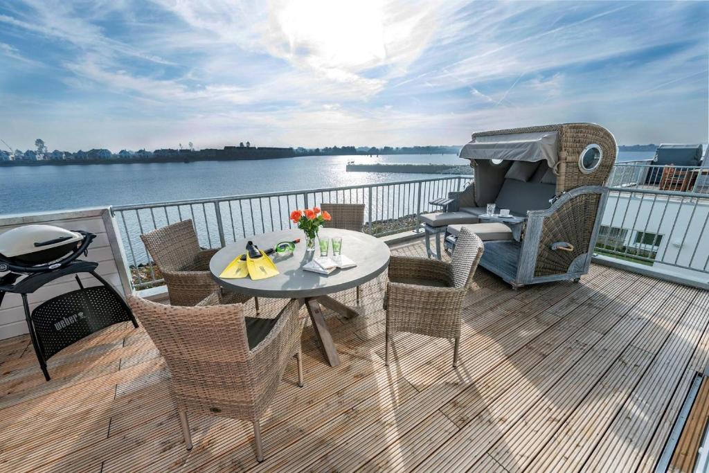 a patio with a table and chairs on a balcony at Bay Watch in Olpenitz