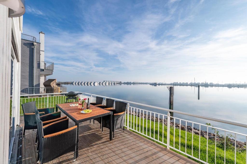 a balcony with a table and chairs and a view of the water at Annas Heimat am Meer in Olpenitz