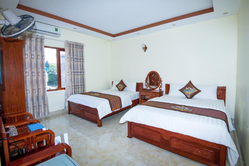 a bedroom with two beds and a window at Ngoc Lan Hotel in Cao Bằng