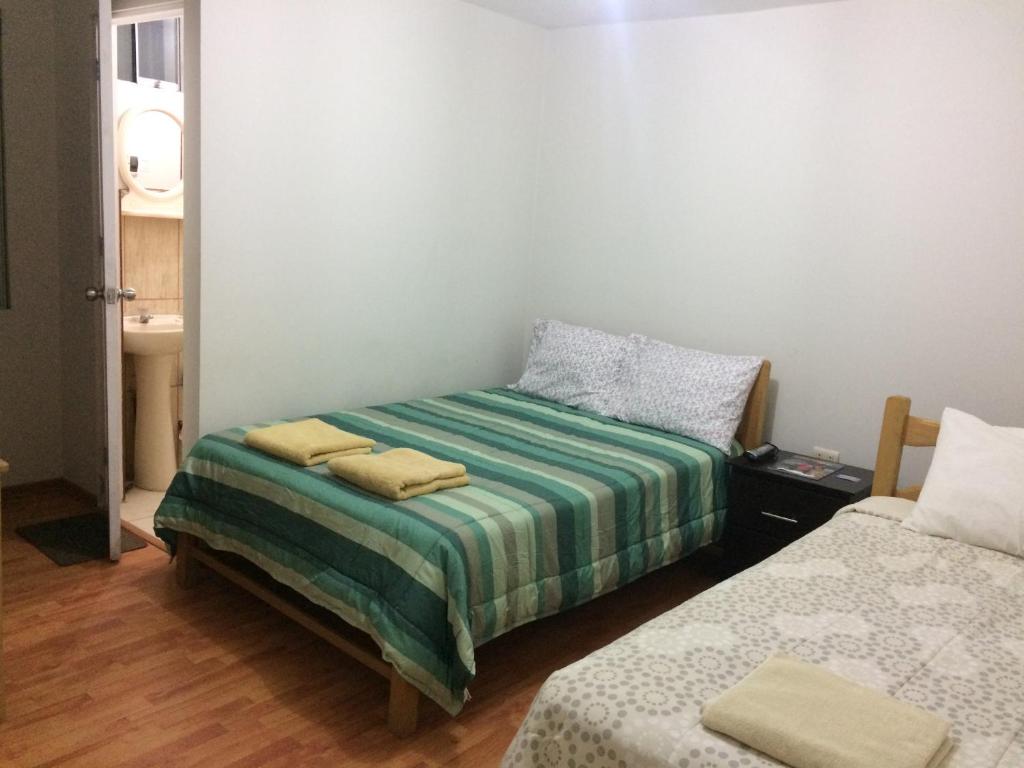 um pequeno quarto com duas camas num quarto em Hospedaje de los Reyes em Huarmey