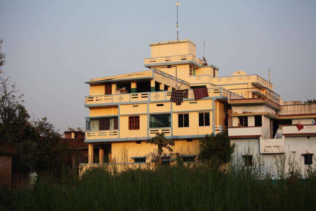 un gran edificio amarillo sentado en la cima de un campo en Ansari House, en Bodh Gaya