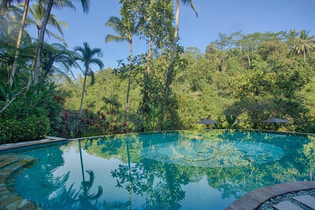 a swimming pool in the middle of a tropical forest at Anahata Villas and Spa Resort in Ubud