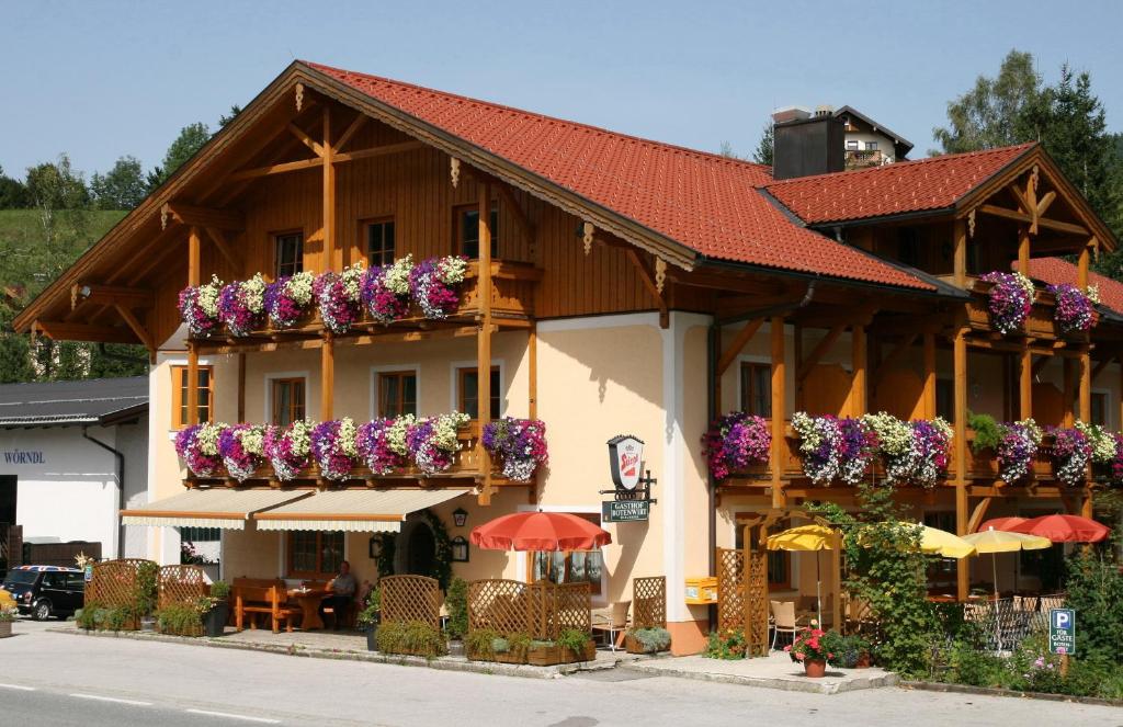 ein Gebäude mit Blumenkästen an der Seite in der Unterkunft Gasthof Botenwirt in Faistenau