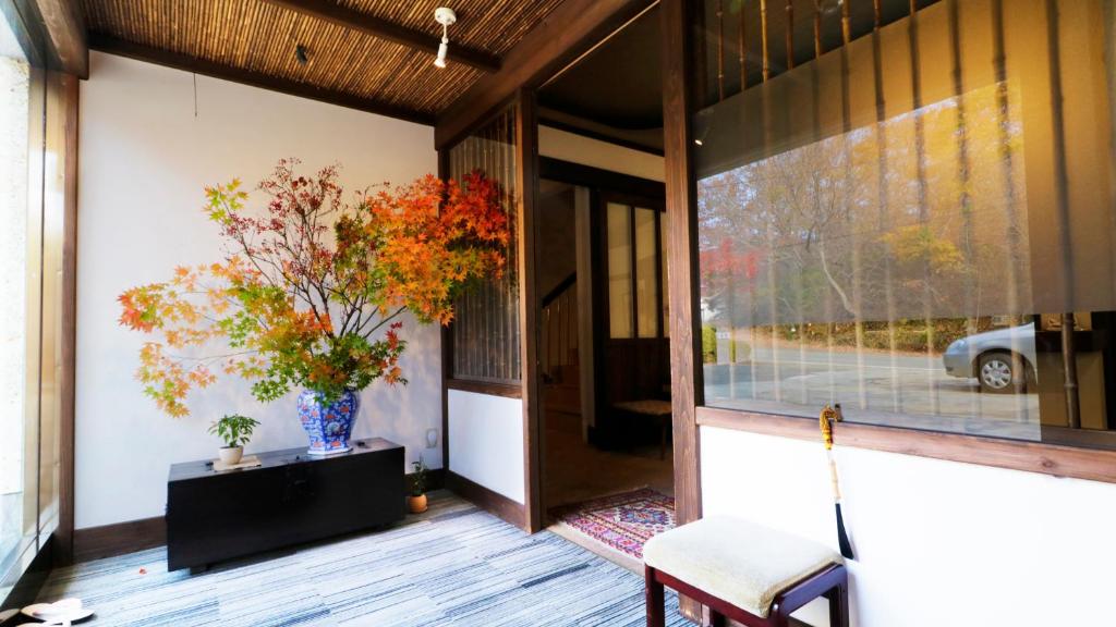 une terrasse couverte avec une chaise et un vase de fleurs dans l'établissement Wakaki Ryokan - Nasu Yumoto Onsen, à Nasu