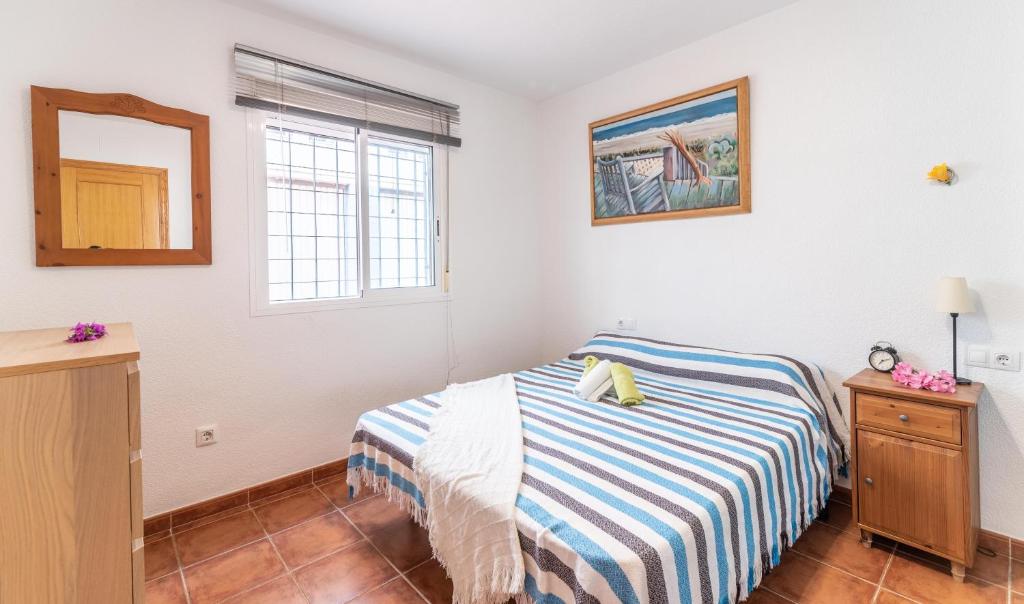 a small bedroom with a bed and a mirror at Apartamento la Isletilla in Almería