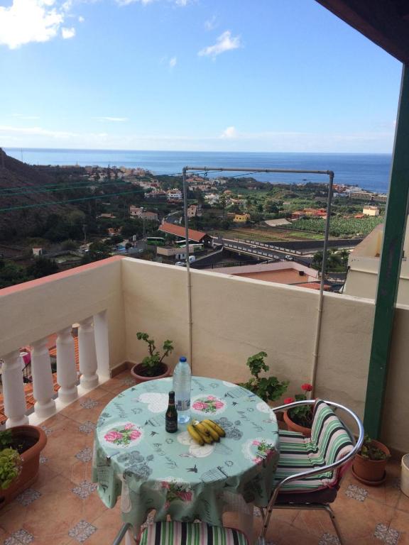 een tafel en stoelen op een balkon met uitzicht op de oceaan bij Casa Cira in Calera