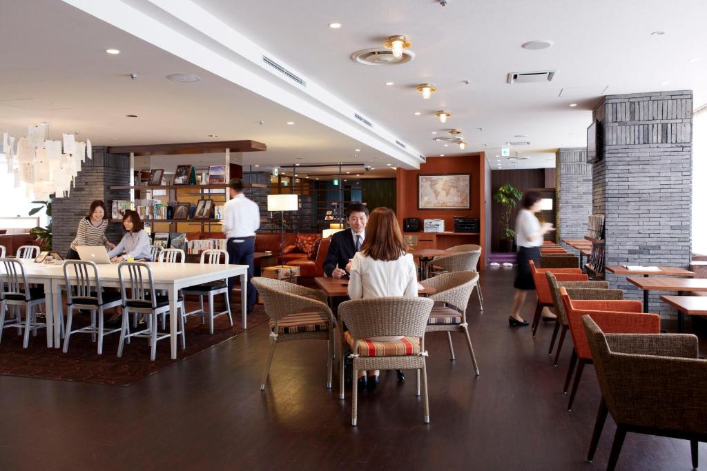 a group of people sitting at tables in a restaurant at Shinagawa Prince Hotel N Tower in Tokyo
