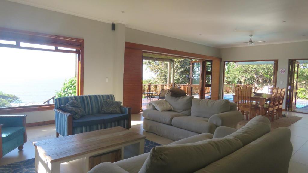 a living room with a couch and chairs and a table at Peace Cottage in Port Shepstone