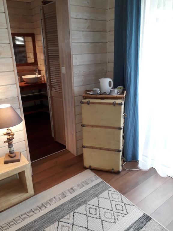 Zimmer mit einer Kommode und einem Tisch mit einer Lampe in der Unterkunft Les Rives du Bassin in Le Teich