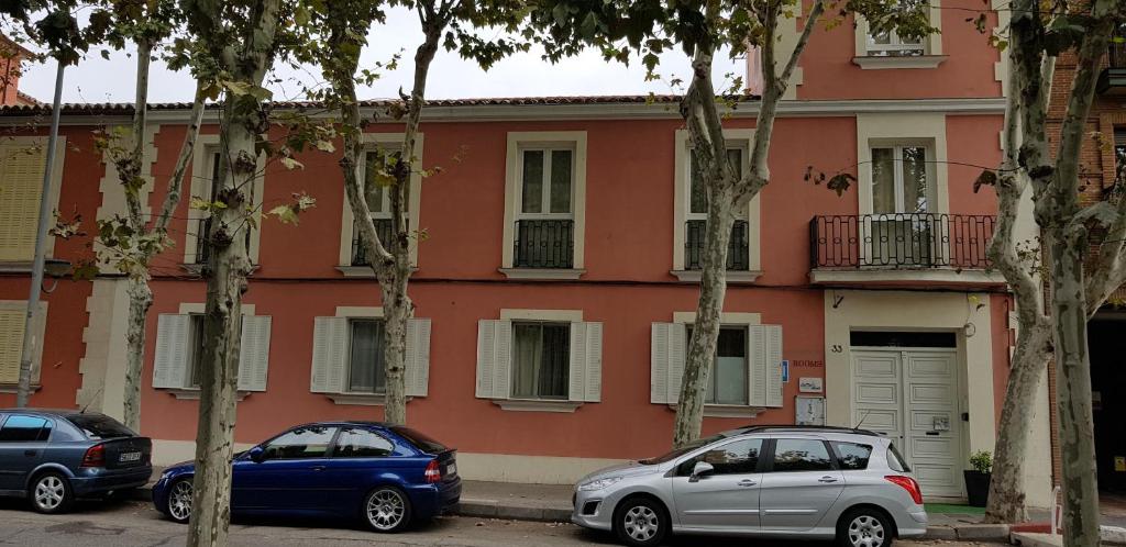 dwa samochody zaparkowane przed budynkiem w obiekcie Casa de Huéspedes con encanto El Sueño del Quijote w mieście Alcalá de Henares