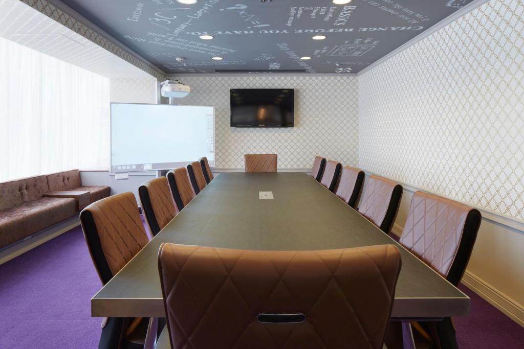 a conference room with a table and chairs and a screen at Shinagawa Prince Hotel N Tower in Tokyo