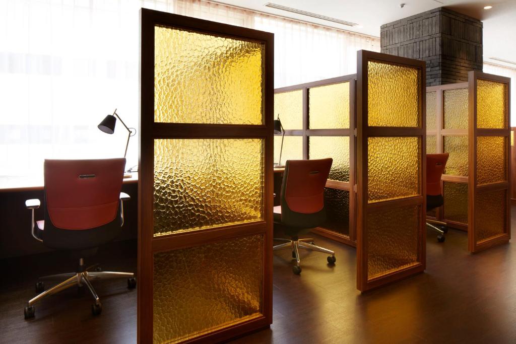 a conference room with a table and chairs and glass partitions at Shinagawa Prince Hotel N Tower in Tokyo
