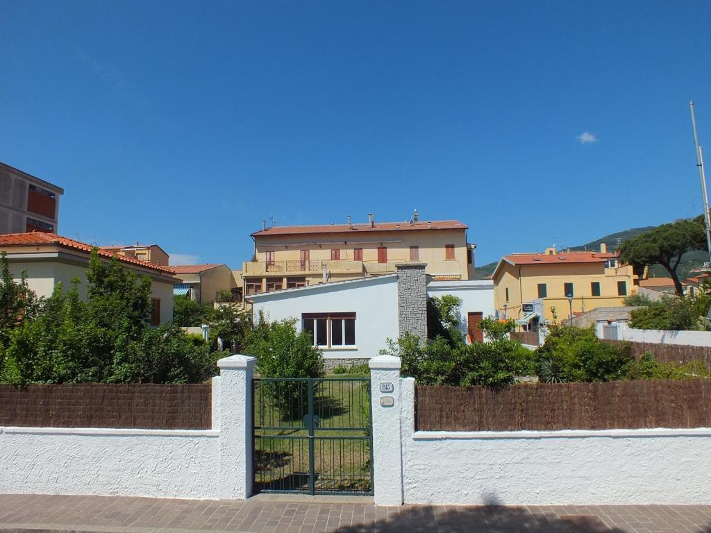 una cerca blanca frente a algunas casas en Villa Mattera en Marina di Campo