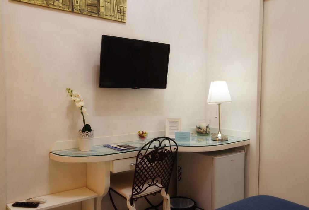 A television and/or entertainment centre at Le Vie Di Napoli B&B