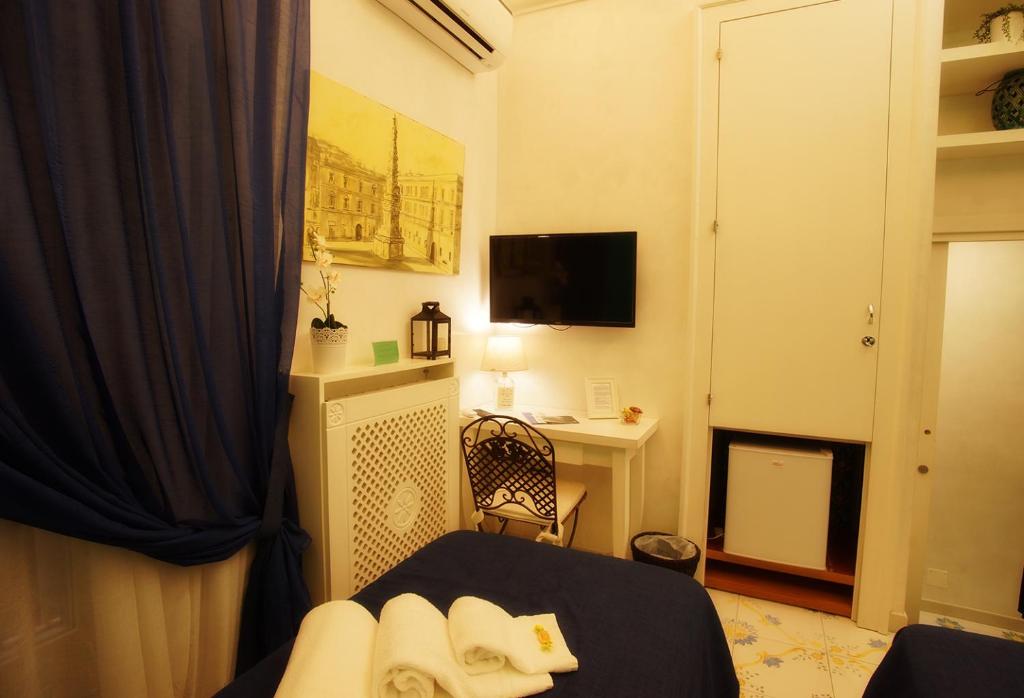 A television and/or entertainment centre at Le Vie Di Napoli B&B
