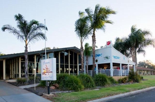 a building with palm trees in front of it at Barmera Lake Resort Motel in Barmera