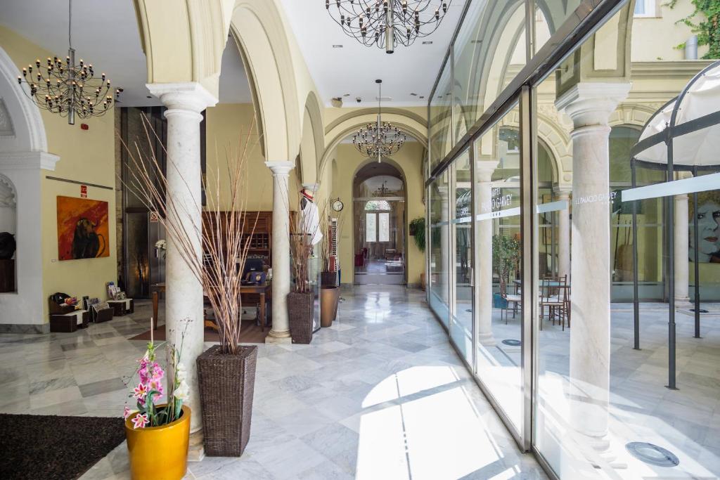 ein großes Gebäude mit Glasfenstern und einer Lobby in der Unterkunft Hotel Palacio Garvey in Jerez de la Frontera